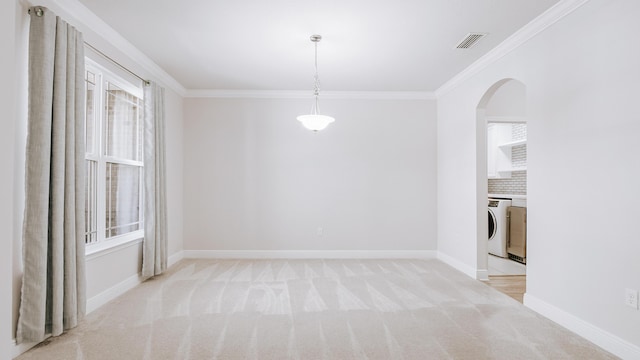 unfurnished dining area with visible vents, ornamental molding, arched walkways, baseboards, and light colored carpet