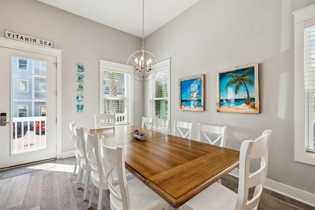 dining area featuring baseboards, an inviting chandelier, and wood finished floors