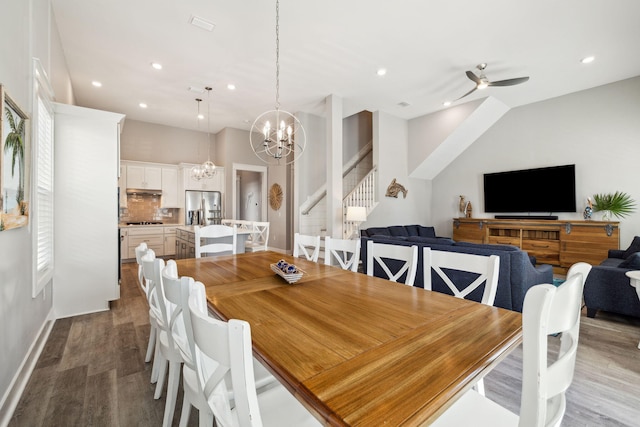 dining space featuring a healthy amount of sunlight, stairway, recessed lighting, ceiling fan with notable chandelier, and wood finished floors