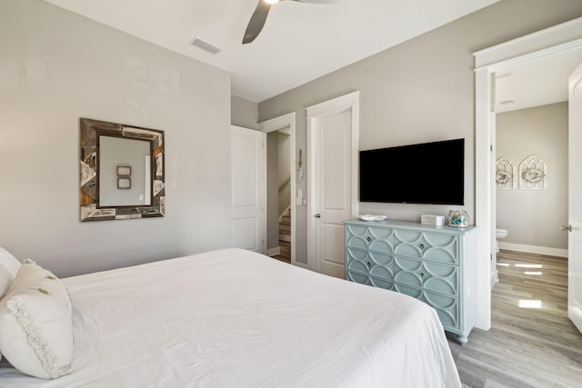 bedroom featuring visible vents, a ceiling fan, baseboards, and wood finished floors