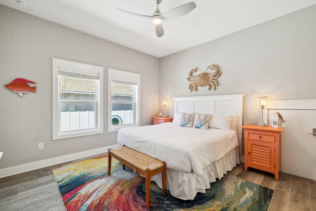 bedroom with baseboards, wood finished floors, and a ceiling fan