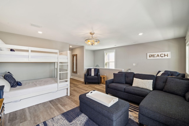 living area with recessed lighting, wood finished floors, visible vents, and baseboards