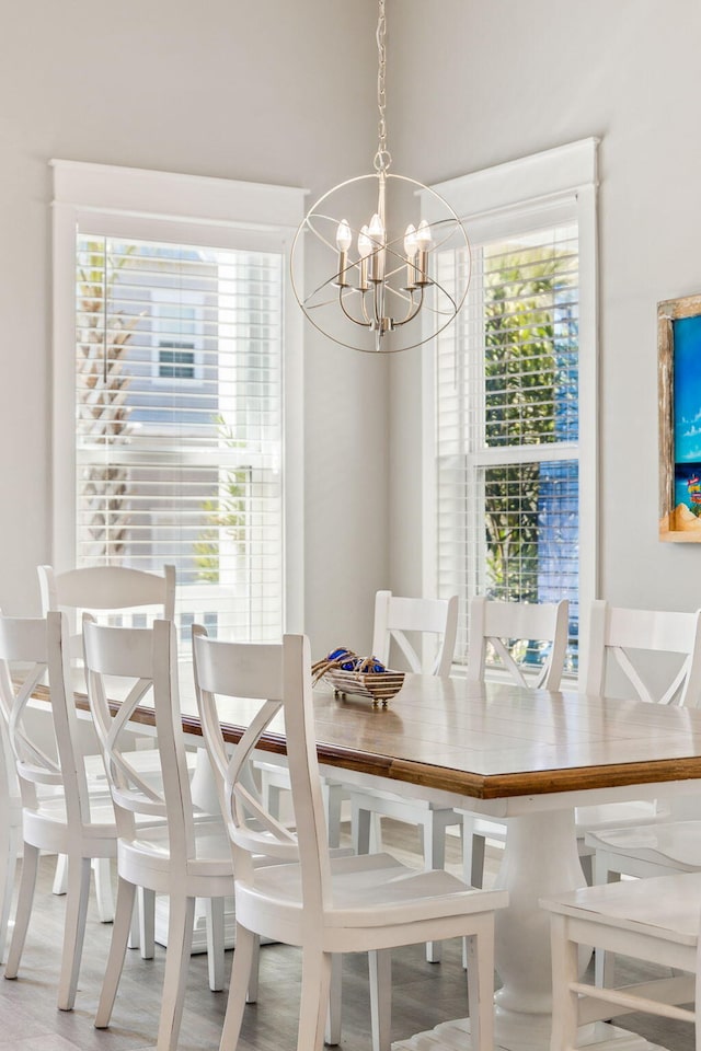 dining space featuring a wealth of natural light, an inviting chandelier, and light wood-style flooring