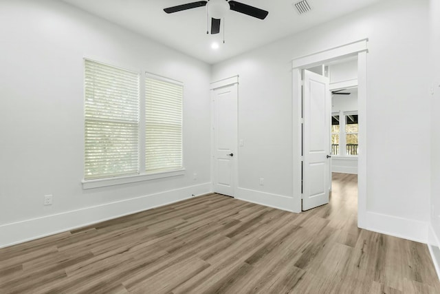 unfurnished bedroom with baseboards, ceiling fan, visible vents, and light wood-style floors