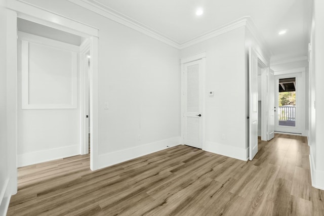 empty room with baseboards, light wood-style floors, recessed lighting, and crown molding