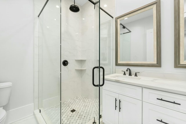 bathroom featuring a stall shower, vanity, and toilet