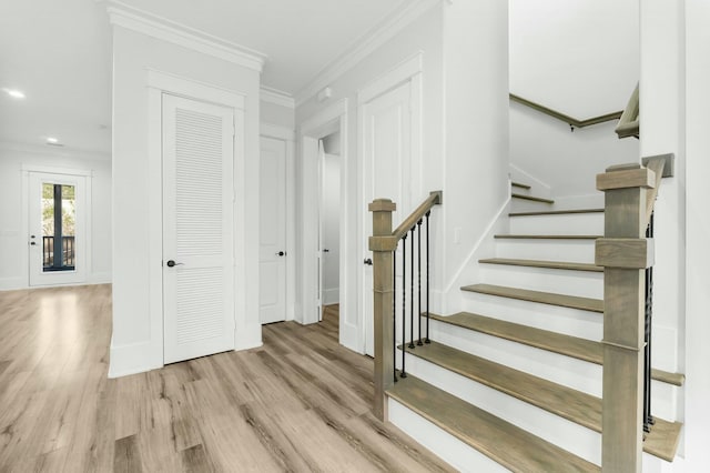 staircase with recessed lighting, crown molding, and wood finished floors