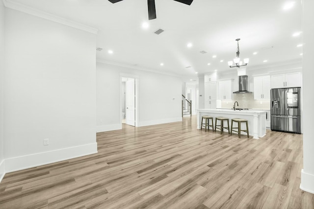 interior space with visible vents, crown molding, light wood-style flooring, and a sink