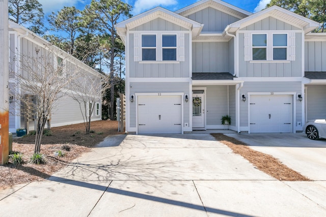 view of front of house with driveway, board and batten siding, an attached garage, and roof with shingles