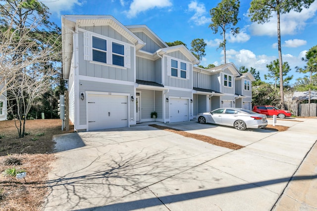 multi unit property with concrete driveway, board and batten siding, and an attached garage