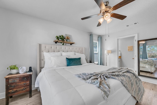 bedroom with multiple windows, wood finished floors, visible vents, and baseboards