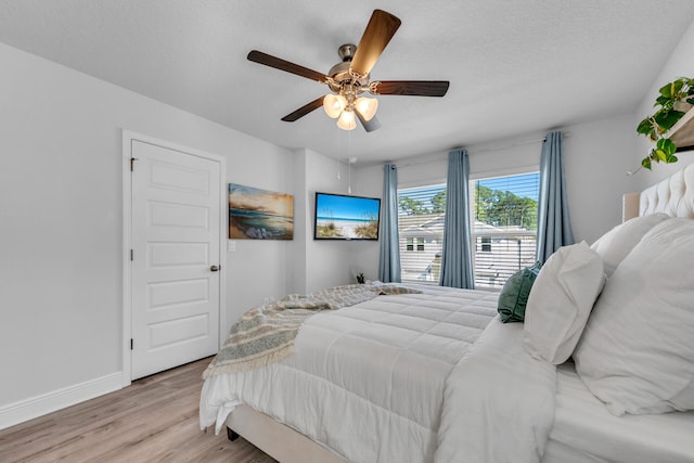 bedroom with a textured ceiling, ceiling fan, wood finished floors, and baseboards