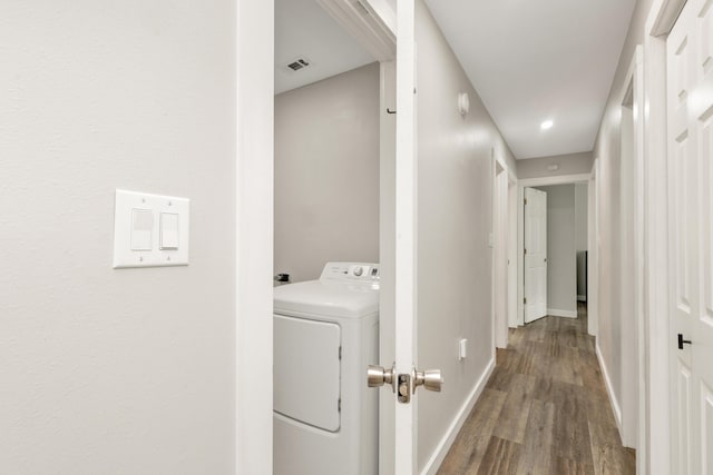 laundry room with laundry area, baseboards, visible vents, washer / clothes dryer, and wood finished floors