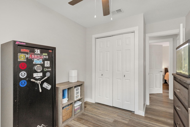 bedroom featuring baseboards, a closet, visible vents, and wood finished floors