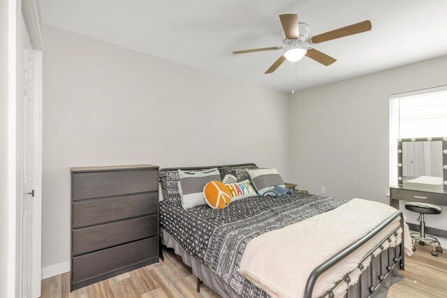 bedroom featuring a ceiling fan, light wood-type flooring, and baseboards