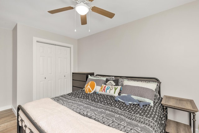 bedroom featuring ceiling fan, a closet, wood finished floors, and baseboards