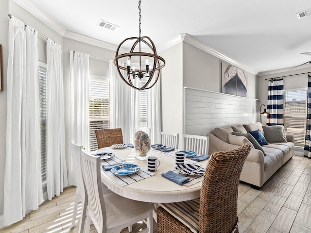 dining room with visible vents, a chandelier, crown molding, and wood finish floors