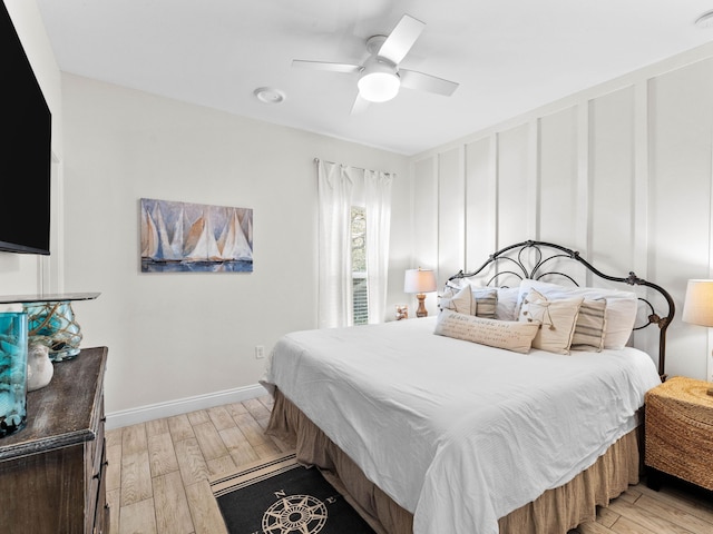 bedroom with ceiling fan, light wood-type flooring, and baseboards