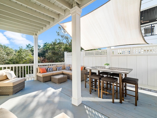 view of patio featuring a deck, outdoor dining space, fence, and an outdoor living space