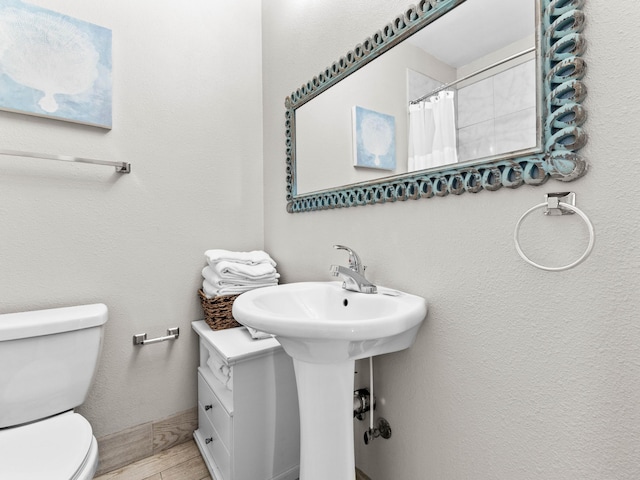 full bathroom with curtained shower, baseboards, toilet, and wood finished floors