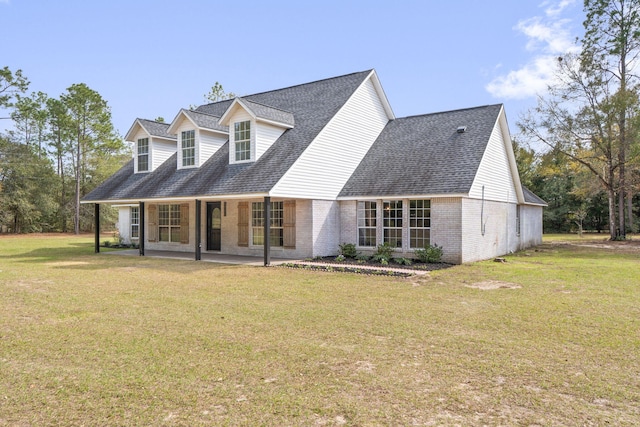 cape cod home with roof with shingles, brick siding, and a front lawn