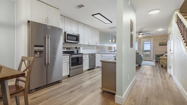 kitchen with stainless steel appliances, decorative backsplash, visible vents, and light wood-style floors