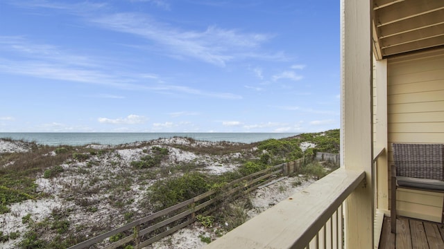 balcony featuring a beach view and a water view