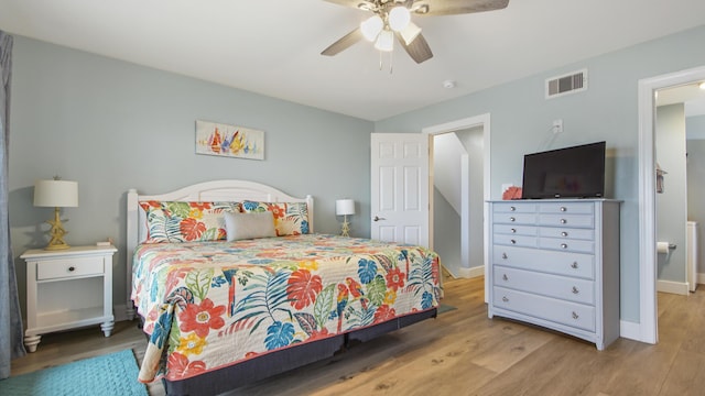 bedroom featuring ceiling fan, wood finished floors, visible vents, and baseboards