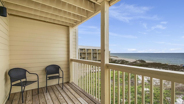 balcony featuring a water view and a beach view