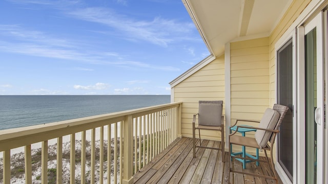 balcony with a water view and a view of the beach