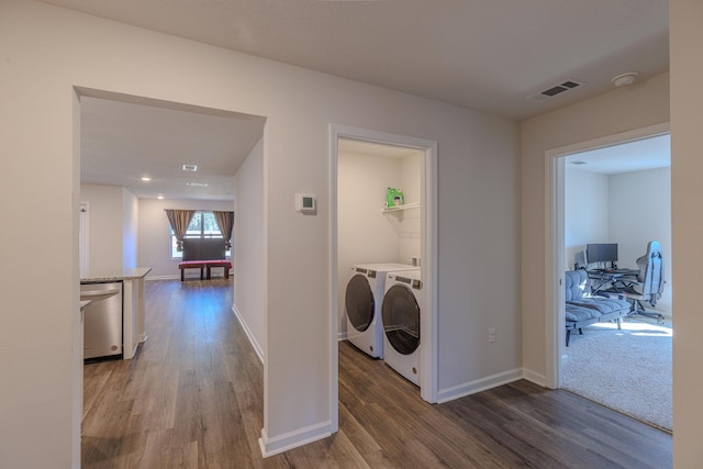 laundry room featuring washing machine and clothes dryer, visible vents, wood finished floors, laundry area, and baseboards