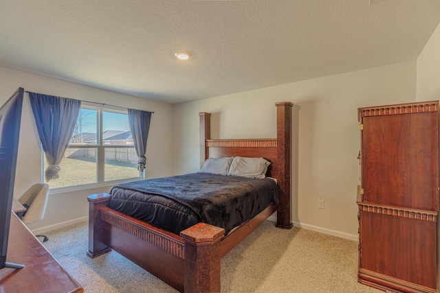 bedroom featuring light carpet, baseboards, and a textured ceiling