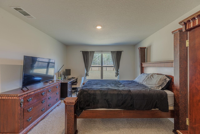 carpeted bedroom with visible vents and a textured ceiling