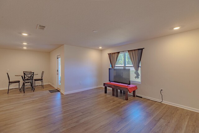 sitting room with light wood finished floors, visible vents, and baseboards