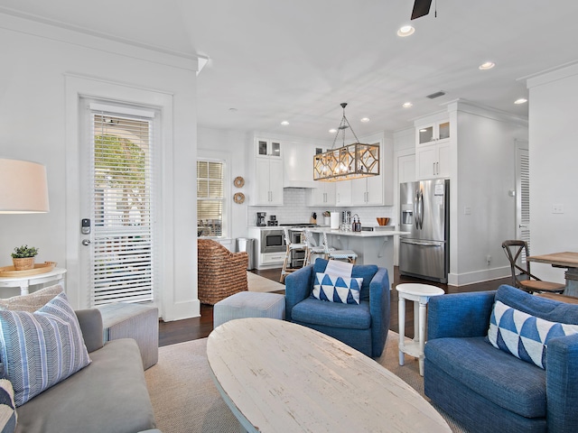 living area with baseboards, visible vents, dark wood-style flooring, and recessed lighting