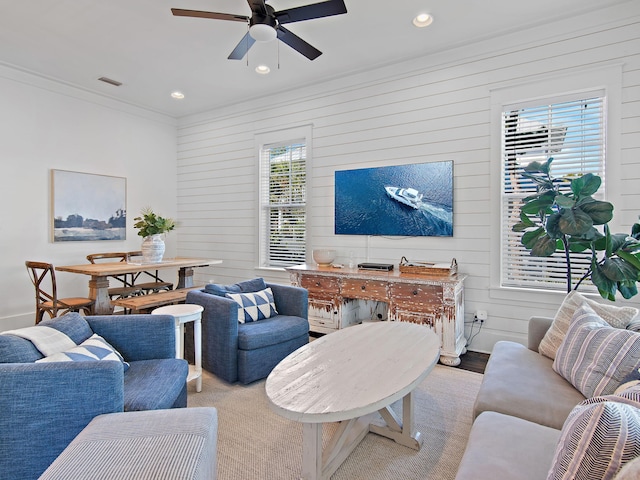 living area with baseboards, visible vents, a ceiling fan, crown molding, and recessed lighting