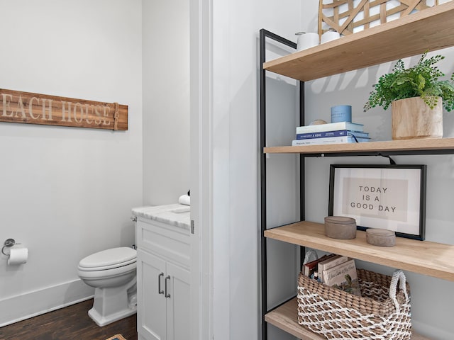 bathroom with wood finished floors, toilet, and baseboards