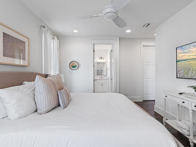 bedroom with ensuite bathroom, recessed lighting, dark wood-type flooring, visible vents, and baseboards