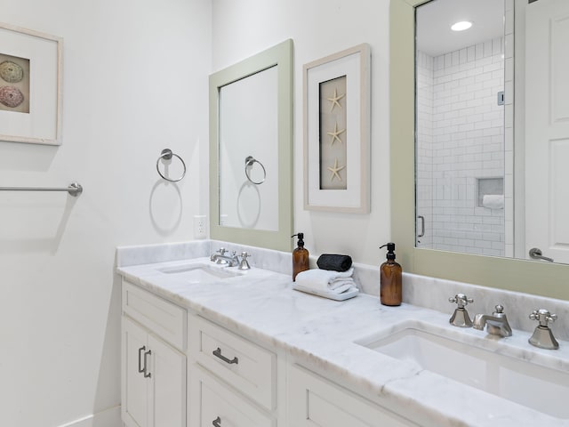 full bathroom with double vanity, a stall shower, and a sink