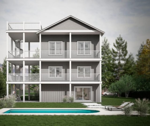 back of property with board and batten siding, a patio area, and a lawn