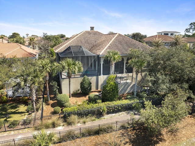 view of front of home featuring stucco siding, fence, and a tiled roof