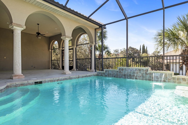 outdoor pool with glass enclosure, ceiling fan, and a patio