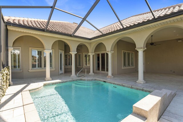 pool featuring a lanai, a patio area, and ceiling fan