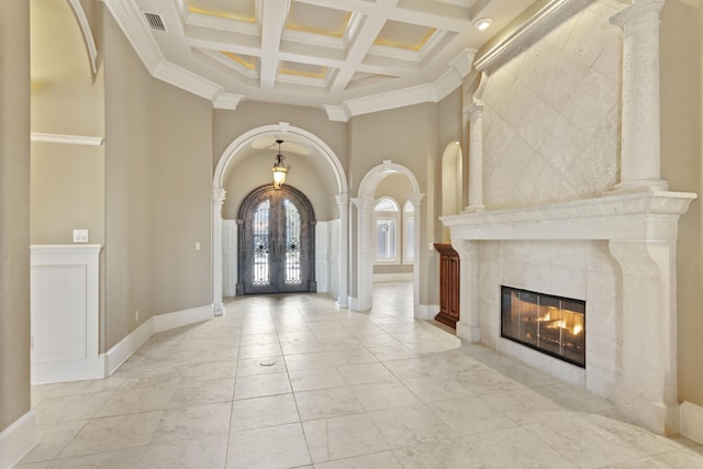 foyer featuring visible vents, arched walkways, coffered ceiling, a high ceiling, and french doors