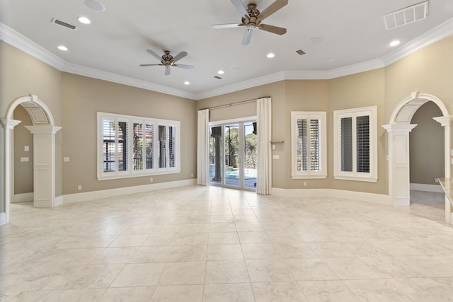 spare room featuring arched walkways, ornamental molding, visible vents, and ornate columns