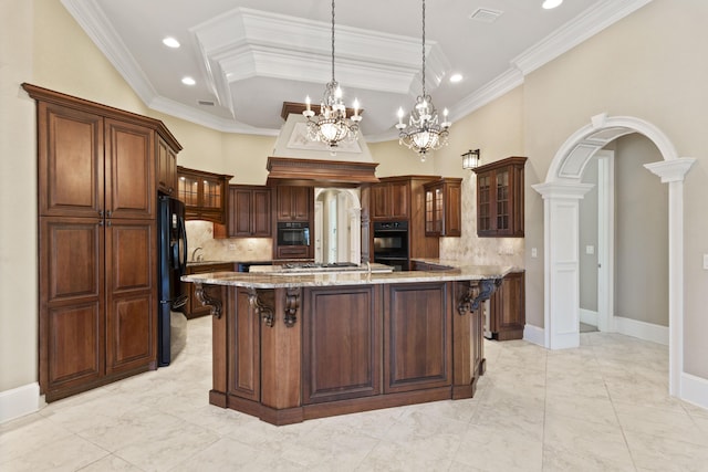 kitchen with light stone countertops, black appliances, a kitchen bar, and arched walkways