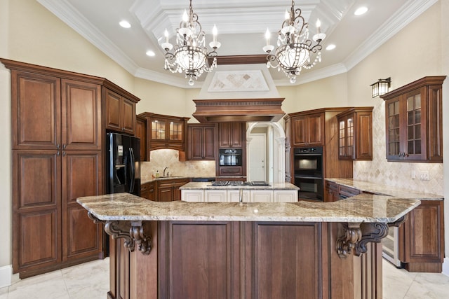 kitchen featuring a spacious island, light stone countertops, black appliances, glass insert cabinets, and pendant lighting