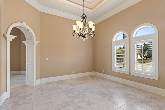 spare room with baseboards, arched walkways, ornamental molding, ornate columns, and a chandelier