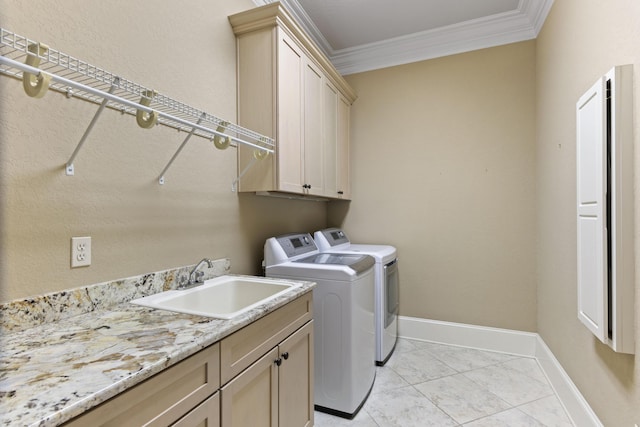 clothes washing area featuring a sink, baseboards, ornamental molding, independent washer and dryer, and cabinet space