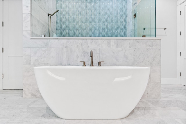 full bath featuring marble finish floor, a soaking tub, tile walls, and walk in shower